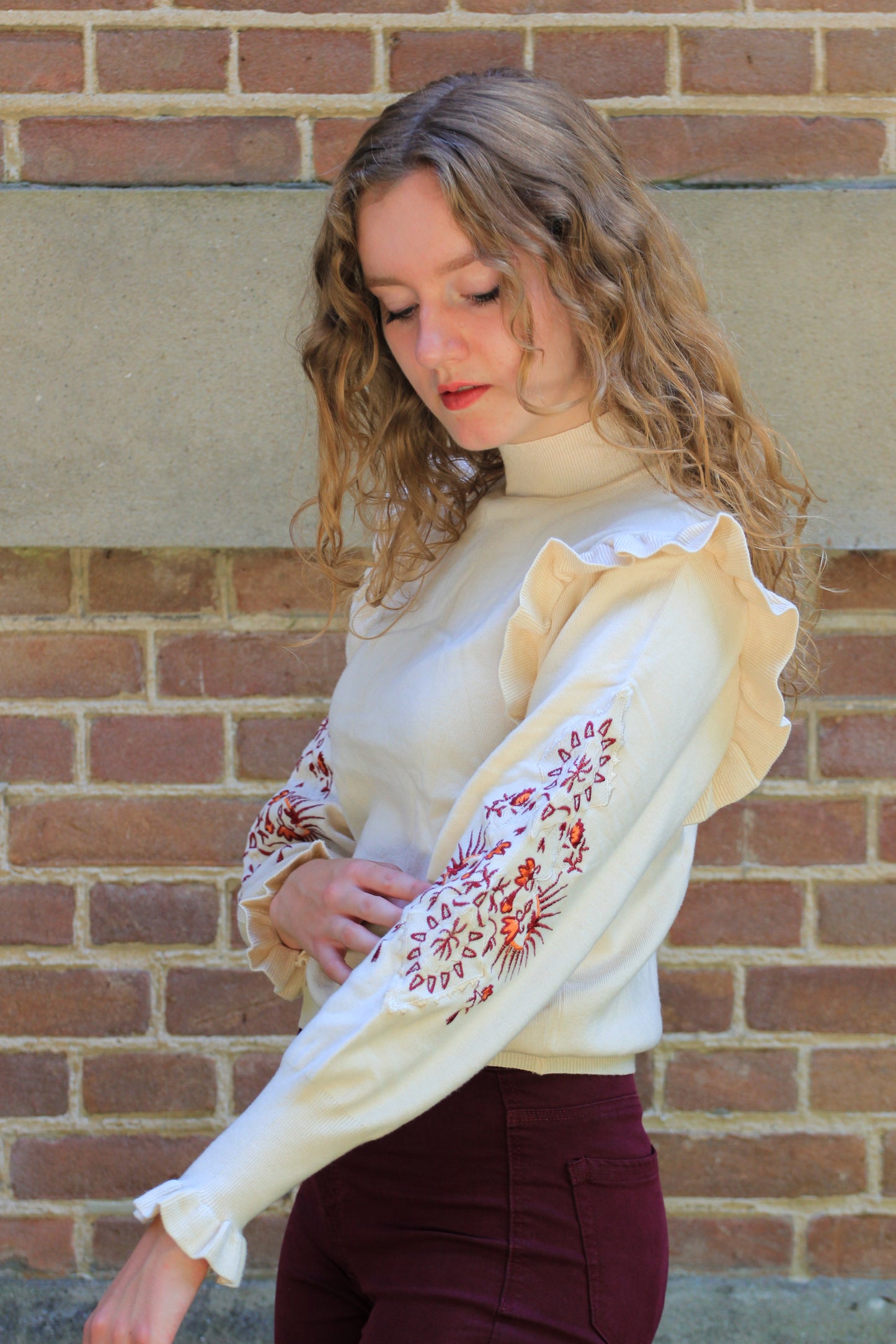 Zijaanzicht van boho trui met ruffles en borduursels, aansluitend boordje bij de nek