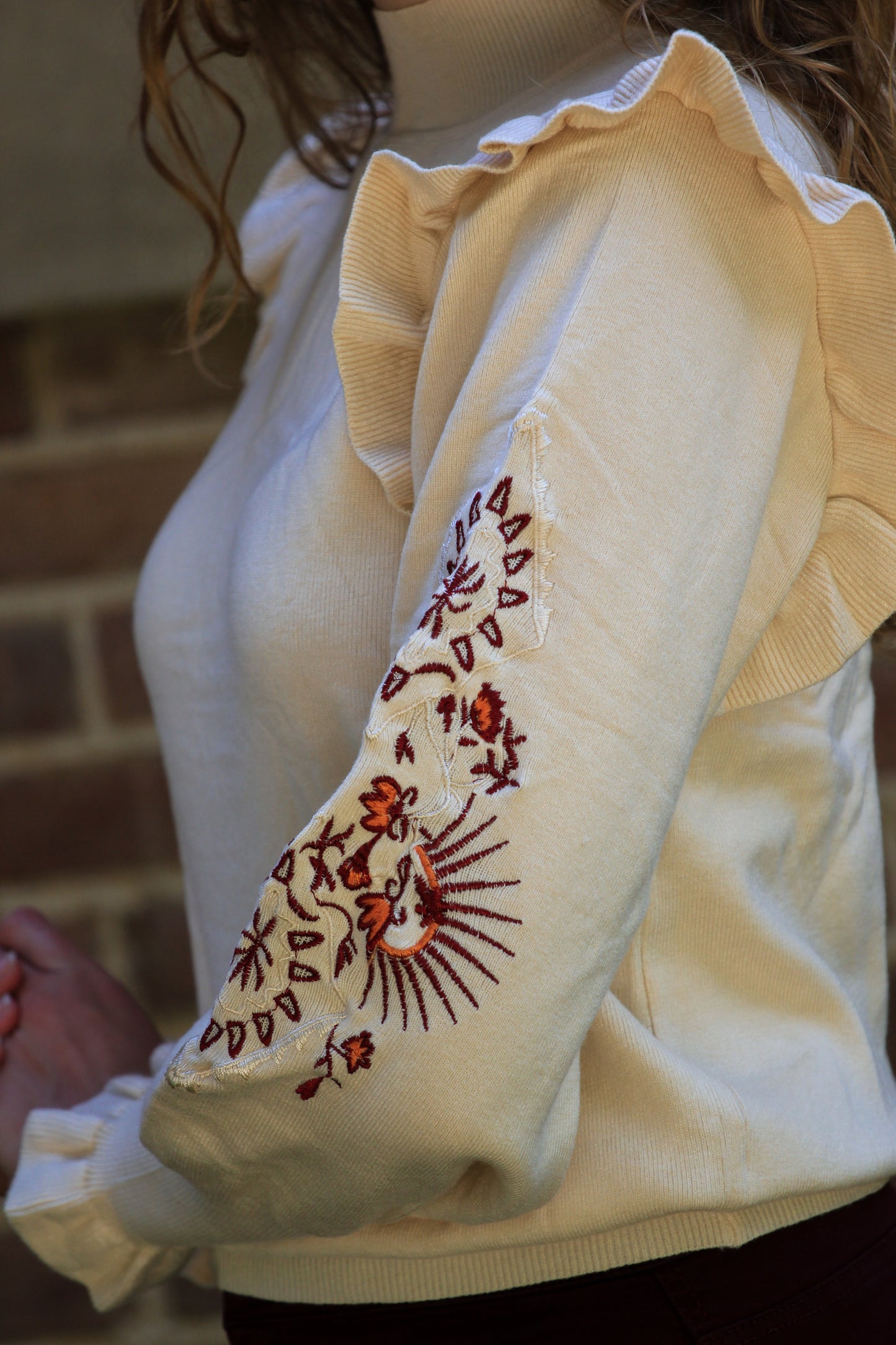 Close-up van boho embroidery en ruffles op zachte trui, viscose en polyester mix