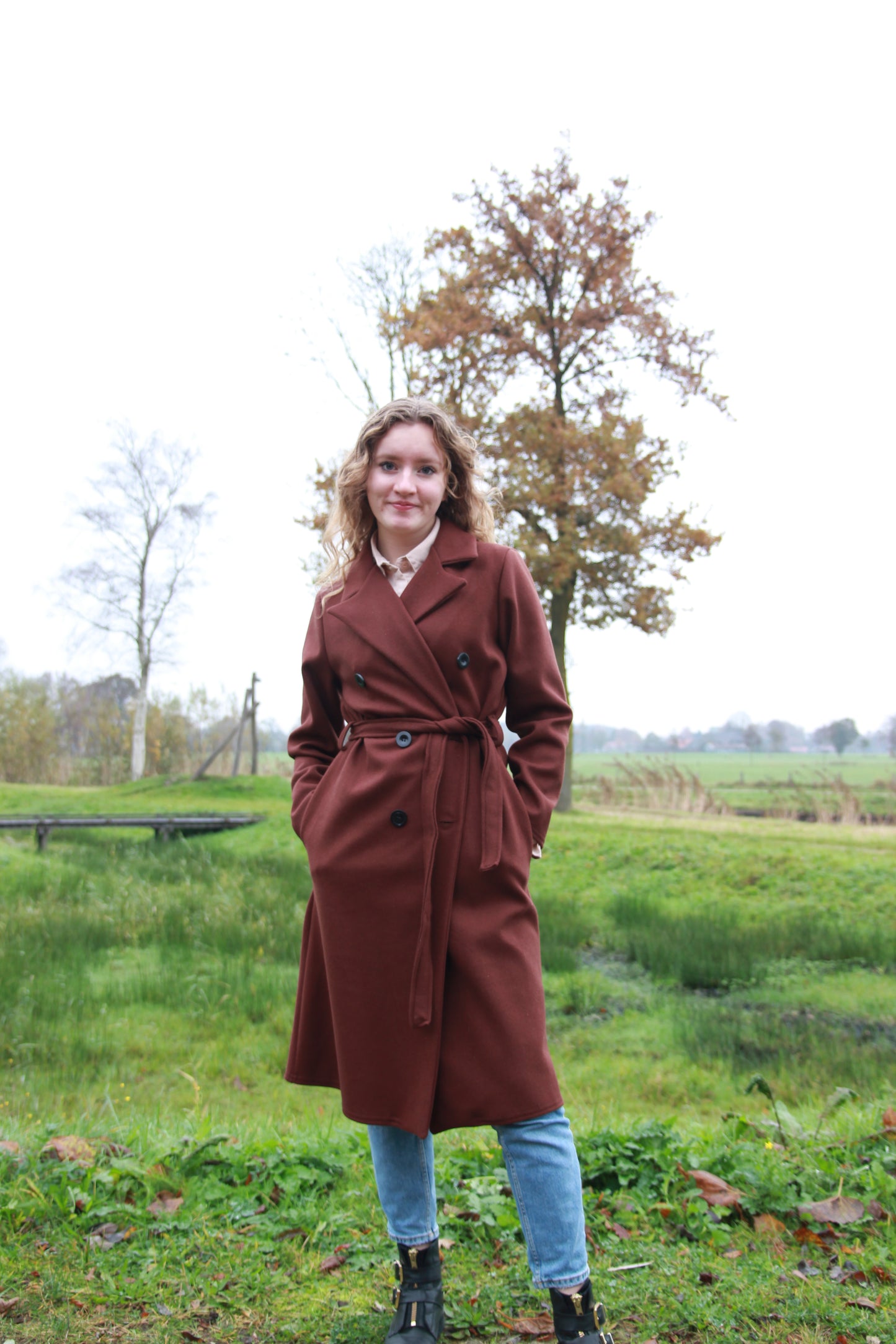 Chique en casual look met donkerbruine trenchcoat, ideaal voor het voorjaar en najaar